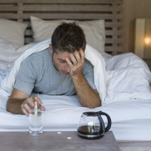 lifestyle home portrait of young exhausted and wasted man waking
